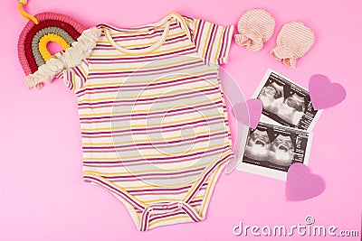 ultrasound (USG) results in sheets and baby clothes with boho rainbow on pink background Stock Photo