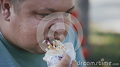 Um fim acima de um homem gordo que coma o coffe prejudicial do fast food e das bebidas em um banco exterior filme Um fim acima de um homem gordo que coma o coffe prejudicial do fast food e das bebidas em um banco exterior filme