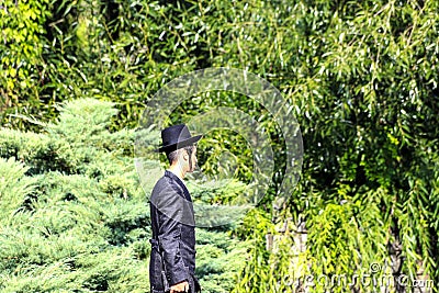 Uman, Ukraine 11.09 2018. A young Jew Hasid boy stands in Uman park , the time of the Jewish New Year, religious Jew Editorial Stock Photo