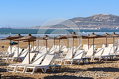 Umbrellas and chaise lounges on beach. Agadir. Morocco Stock Photo