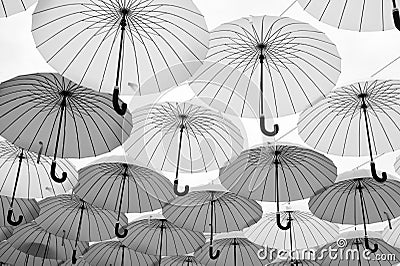 Umbrellas float in sky on sunny day. Umbrella sky project installation. Outdoor art design and decor. Holiday and Editorial Stock Photo