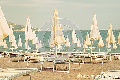 Umbrellas and loungers for relax and comfort on sea beach. Happy summer vacations and tourism concept. Stock Photo