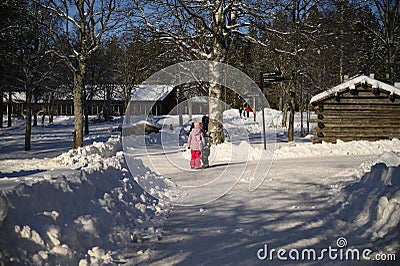 Umea, Sweden - March 07, 2020 Tranquil view of kids playing under the shadow of pine tree on untouched snow Editorial Stock Photo