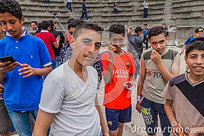 UMM QAIS, JORDAN - MARCH 30, 2017: Young boy tourists visit the West Theatre ruins in Umm Qa Editorial Stock Photo