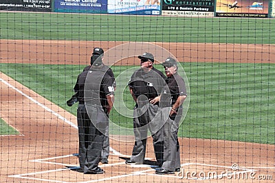 Umpires Meeting on the Other Side of the Backstop Editorial Stock Photo