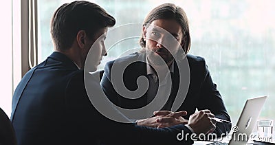 Un experto en serio, un cliente de consultoría de software con portátil Un experto en serio, un cliente de consultoría de software con portátil