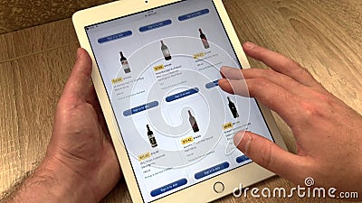 Un homme sélectionne le vin et les autres types d'alcool dans un magasin en ligne à l'aide d'un comprimé. Le choix des marchandise banque de vidéos Un homme sélectionne le vin et les autres types d'alcool dans un magasin en ligne à l'aide d'un comprimé. Le choix des marchandise banque de vidéos