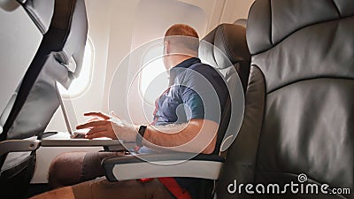 Un jeune homme s'asseyait sur l'avion et travaillait sur son ordinateur portable avant le départ banque de vidéos Un jeune homme s'asseyait sur l'avion et travaillait sur son ordinateur portable avant le départ banque de vidéos