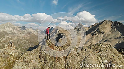 Un jeune type de hippie avec une barbe un grimpeur dans un chapeau et des lunettes de soleil se tient sur une arête rocheuse haut banque de vidéos Un jeune type de hippie avec une barbe un grimpeur dans un chapeau et des lunettes de soleil se tient sur une arête rocheuse haut banque de vidéos