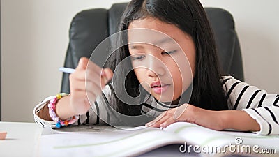 Una bambina asiatica che fa i compiti con la felicità per il concetto di auto-apprendimento e di educazione domestica seleziona f video d archivio Una bambina asiatica che fa i compiti con la felicità per il concetto di auto-apprendimento e di educazione domestica seleziona f video d archivio