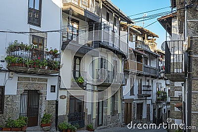 Una estrecha calle con arquitectura tradicional y balcones de madera en la hermosa villa de Candelario, EspaÃ±a Editorial Stock Photo