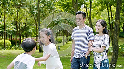 Una famiglia asiatica di 4 che cammina & che ride nel parco di estate soleggiata al rallentatore archivi video Una famiglia asiatica di 4 che cammina & che ride nel parco di estate soleggiata al rallentatore archivi video