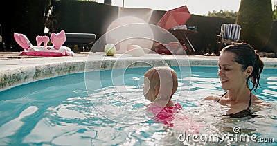 Una Madre Joven Enseña a Su Hija a Nadar En La Piscina Durante Las  Vacaciones De Verano Almacen De Video - Vídeo de muchacha, recorrido:  229202375