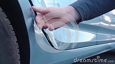 Una mano maschile che gratta un dente sulla porta di un'auto distrutta, controlla crepe e trucioli di vernice, schiacciando un di archivi video Una mano maschile che gratta un dente sulla porta di un'auto distrutta, controlla crepe e trucioli di vernice, schiacciando un di archivi video