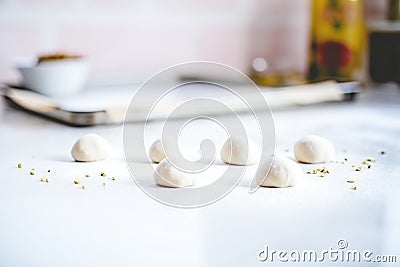 unbaked naan dough balls lined up on a floured surface Stock Photo