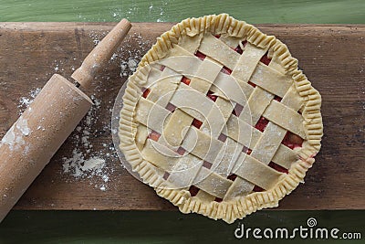 Unbaked pie with rolling pin on wooden surface Stock Photo