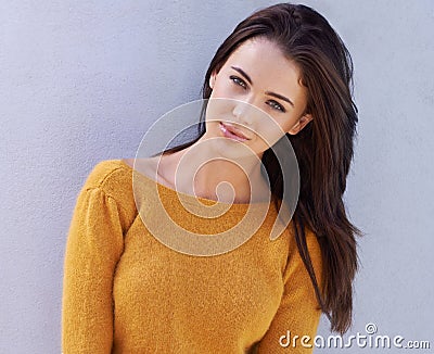Unbelievable beauty. Portrait of a beautiful young woman standing confidently against a gray wall. Stock Photo