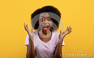 Unbelievable. Shocked african american woman screaming with open mouth, looking at camera over yellow background Stock Photo