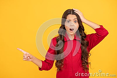 this is unbelievable. shocked kid presenting product on yellow background. child surprised with sale Stock Photo