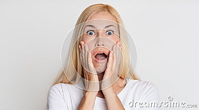 Unbelievable! Shocked woman holding hands on cheeks Stock Photo