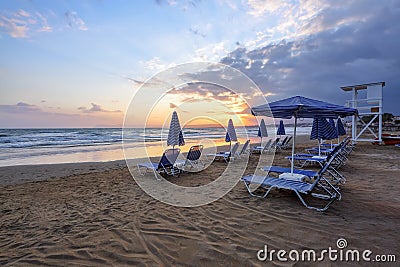 Unbelievable sunrise. Empty beach with umbrellas and deck chairs closed. Beautiful summertime view seascape. Morning landscape. Stock Photo