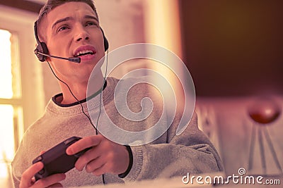 Uncertain teenage boy using gamepad playing games Stock Photo