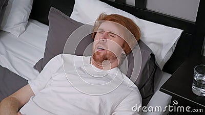 Uncomfortable Man Lying in Bed Feeling Unrest Stock Photo