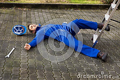 Unconscious technician fell from ladder on street Stock Photo