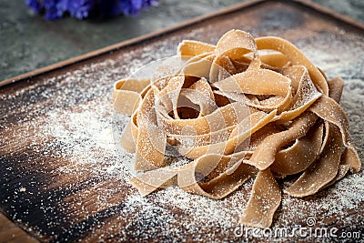Uncooked brown pasta tagliatelle with chestnuts Stock Photo