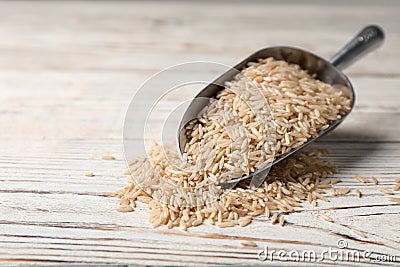 Uncooked brown rice in metal scoop Stock Photo