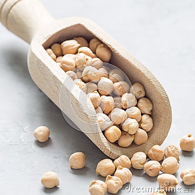 Uncooked dry chickpeas in wooden scoop, closeup, square Stock Photo