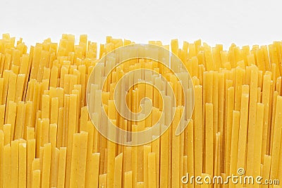 Uncooked durum fettuccine pasta on white background. Raw spaghetti or noodles Stock Photo
