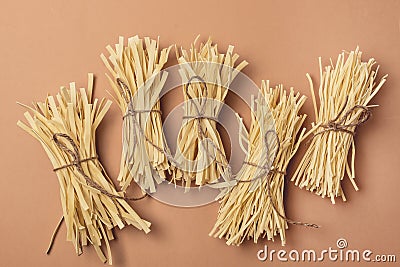 Uncooked Noodle Homemade Drying Wheat Noodles on Light Brown Background Top View Horizontal Stock Photo