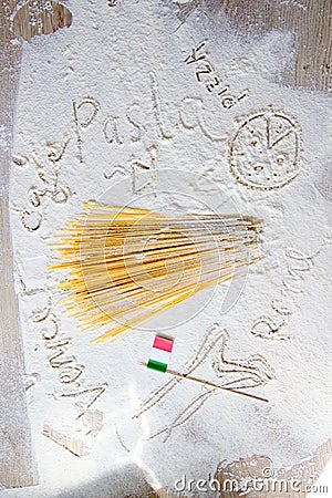 Uncooked pasta spaghetti macaroni and italian flag. Words Venice, Rome and Pasta written in flour Stock Photo