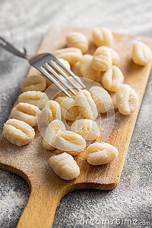 Uncooked potato gnocchi on cutting board. Tasty italian food Stock Photo