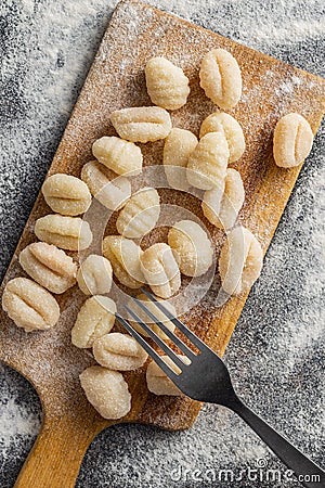 Uncooked potato gnocchi on cutting board. Tasty italian food Stock Photo