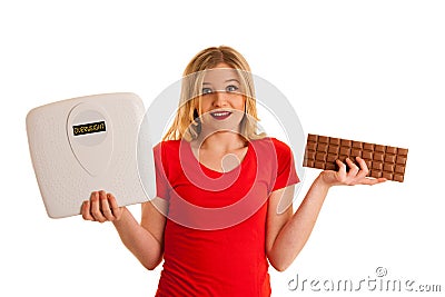 Undecided woman holding scale and chocolate uncertain wether to Stock Photo