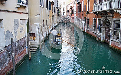 Undefined gondolier operate gondola through the narrow canal of Venice Editorial Stock Photo