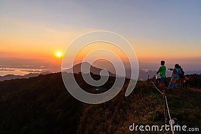 Undefined traveler standing on high mountain in sunset time Editorial Stock Photo