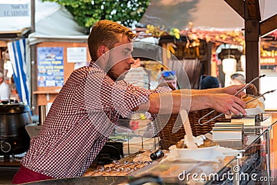 An undefinite male person on the sausage market working and serving fresh cooked food Editorial Stock Photo