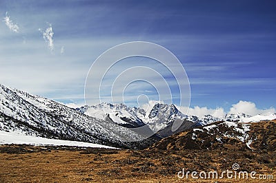 Under the blue sky and white clouds, a beautiful, huge and quiet snowy mountain Stock Photo