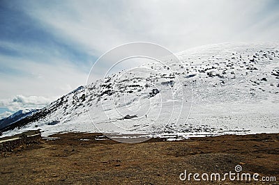 Under the blue sky and white clouds, a beautiful, huge and quiet snowy mountain Stock Photo