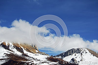 Under the blue sky and white clouds, a beautiful, huge and quiet snowy mountain Stock Photo