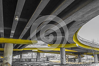 Under a concrete road bridge with yellow pillars Stock Photo