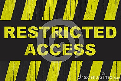 Restricted access text warning sign with yellow and black stripes painted over cracked wood Stock Photo