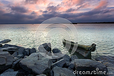 Under the rosy clouds were wooden sailboats and ro Stock Photo