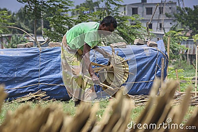 Under the sun light dying hand held fan leaf palm leaf. Editorial Stock Photo