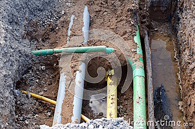 Underground services, including telecom, gas, electricity fibre optic ducts, exposed for repair during groundworks and new road Stock Photo