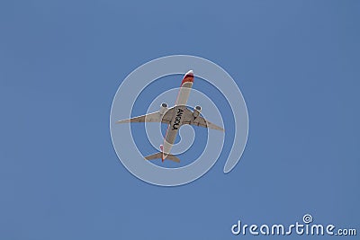 Underside view of a commercial airliner flying Editorial Stock Photo
