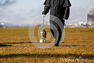 Undertaker carrying an urn with ashes of cremated human Stock Photo